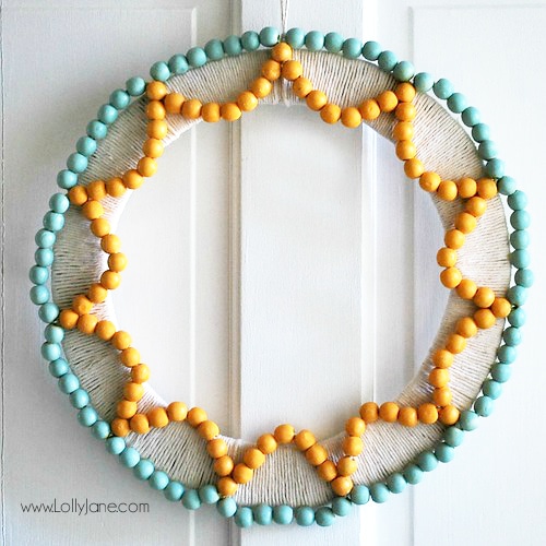 Such a fun handmade wood bead wreath! Learn how to make this wreath with beads, paint and a little time to craft! #beadwreath #handmadewreath #woodbeadwreath #howtomakewoodbeadwreath #wreathtutorial