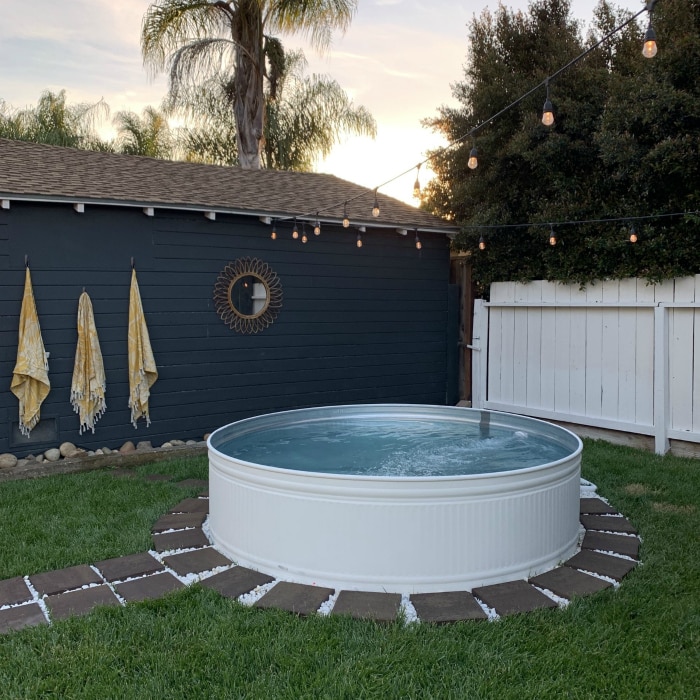 Learn how to make a pool out of a stock tank with a little paint and a filter! Fun in the sun never looked so good! #stocktank #stocktankpool #summerideas #stocktankpoolideas #whitestocktank #paintedstocktank