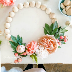 Learn how to make this easy wooden bead wreath with florals. Such a fun front door wreath with natural wood beads and pretty florals and berries. #woodbeadwreath #floralwreath #howtomakeawreath #easywreathtutorial #splitwoodbeadwreath