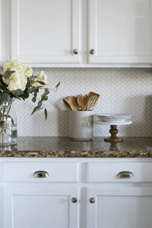 The herringbone tile pattern is a classic design that's always in style. Installing this herringbone kitchen backsplash was an affordable way to update our tract home kitchen.